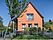 Privatbauherr Berlin Brandenburg Einfamilienhaus mit orangener Fassade und kleinem Vorgarten